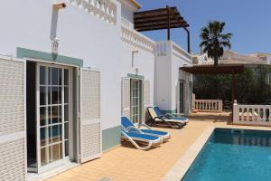 a villa with a swimming pool and two lounge chairs at Stunning Villa with Pool & View near beach in Budens