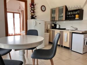 バダチォエンターダミッツにあるAnnApartmanのキッチン(テーブル、椅子、白い冷蔵庫付)