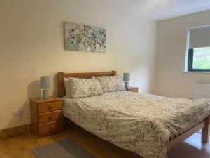 a bedroom with a bed and a nightstand with two lamps at Cottage 442 - Oughterard in Oughterard