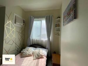 Habitación pequeña con cama y ventana en Affordable Vacation Rental in San Jose Del Monte Bulacan, en Tunkong Manga