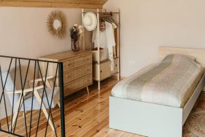 a bedroom with a bed and a dresser and a mirror at Domek Discovery Mazury in Mrągowo
