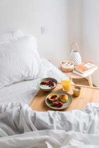 ein Frühstückstablett mit Frühstücksprodukten auf einem Bett in der Unterkunft Lux Praia da Barra Aveiro A 20 metros da Praia. in Gafanha da Nazaré