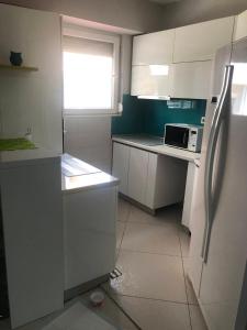 a kitchen with white cabinets and a refrigerator at Bube Apartment in Skopje