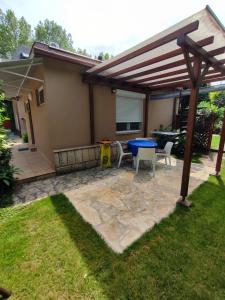 a patio with a blue table and chairs in a yard at Apartman Valentin in Siófok