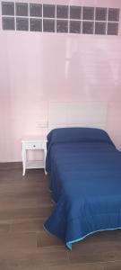 Un dormitorio con una cama azul y un escritorio. en La casita azul, en Torrevieja