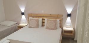 a small bedroom with a bed and two pillows at Apart-Hotel Llazari in Himare