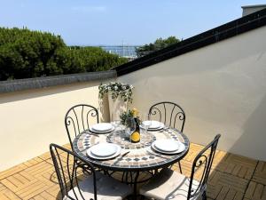 ein Tisch und Stühle auf einer Terrasse in der Unterkunft Attico in Piazza Matteotti in Desenzano del Garda