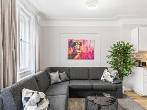 a living room with a gray couch and a painting at SKY9 Apartments Schönbrunn Palace in Vienna