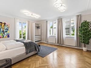 a white bedroom with a large bed and windows at SKY9 Apartments Schönbrunn Palace in Vienna