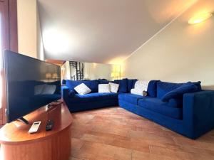 un soggiorno con divano blu e tavolo di Attico in Piazza Matteotti a Desenzano del Garda