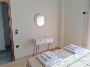 a white bedroom with a bed and a mirror at Christine luxury villa in Kolymvari