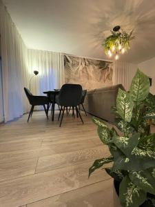 uma sala de estar com mesa, cadeiras e plantas em Scandiland Apartment em Brasov