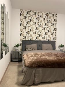 um quarto com uma cama grande e uma parede em Scandiland Apartment em Brasov
