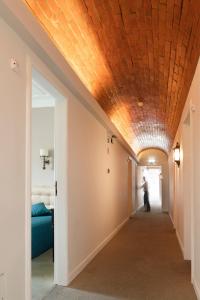 a hallway with a coffered ceiling and a man walking down it at Hotel Joao Padeiro in Aveiro