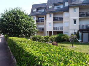 a large apartment building with a hedge in front of it at ker Mamie in Merville-Franceville-Plage
