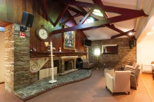 a living room with a fireplace and a clock on a wall at Hotel Joao Padeiro in Aveiro