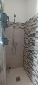 y baño con ducha y pared de azulejos. en La casita azul, en Torrevieja 32 fotos más