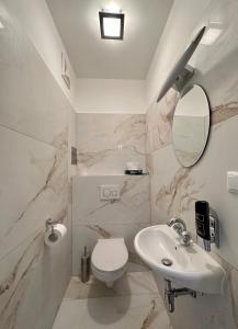 a bathroom with a sink and a toilet and a mirror at Klimt Apartments in Vienna