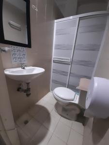 a white bathroom with a toilet and a sink at Rivera Hostel in Santa Marta +17 photos