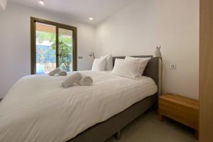 a bedroom with a large white bed with a window at Mansfield vue carte Postale Terrasse Piscine 2 in Menton +25 photos