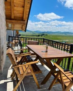 a wooden table and chairs on top of a balcony at WOLFOREST in Žabljak