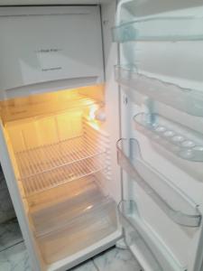 an empty refrigerator with its door open with the light on at APARTAMENTO - 2 quartos in Campo Grande