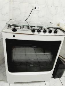 um forno de fogão branco sentado numa cozinha em 2 quartos com ar - Apto em condomínio em Campo Grande