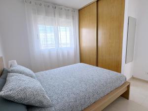 a bedroom with a bed and a wooden cabinet at AT-Pineda-03 in La Pineda