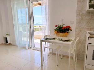 a white table and chairs in a kitchen with a window at AT-Pineda-03 in La Pineda