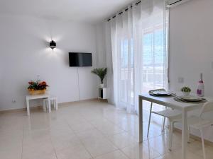sala de estar blanca con mesa y TV en AT-Pineda-03 en La Pineda