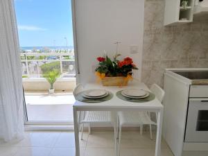 a kitchen with a table with a vase of flowers on it at AT-Pineda-03 in La Pineda