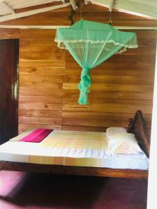 a bed in a room with a wall with a window at Lake view cabana Paradise & Villa in Tangalle
