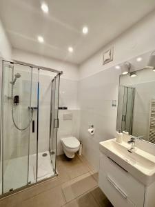 a bathroom with a shower and a toilet and a sink at Klimt Apartments in Vienna