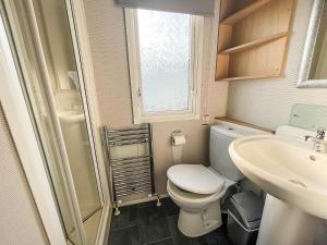 a small bathroom with a toilet and a sink at Lovely 8 Berth Caravan Nearby Scratby Beach In Norfolk Ref 50021f in Great Yarmouth