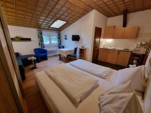 ein Schlafzimmer mit 2 Betten und eine Küche mit einem Tisch in der Unterkunft Alpen-Appartementhof in Bad Hofgastein