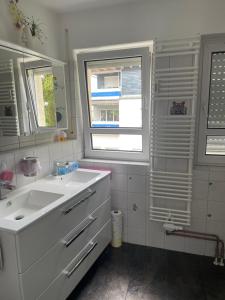 ein weißes Bad mit einem Waschbecken und einem Fenster in der Unterkunft Möblierte Wohnung für Geschäftsreisen/Ferienwohnung Plauen Stadtmitte in Plauen