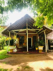 a small house with a thatched roof at Lake view cabana Paradise & Villa in Tangalle