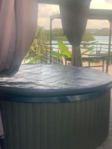 a hot tub with a table and chairs on a deck at Bienvenue à la Villa Duprey in Le Marin