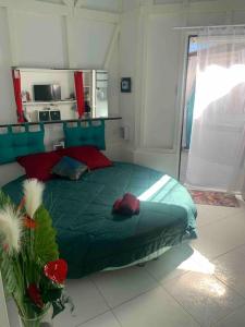 a bedroom with a green bed in a room at Bienvenue à la Villa Duprey in Le Marin