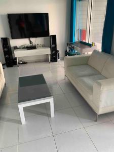 a living room with a couch and a table and a tv at Bienvenue à la Villa Duprey in Le Marin