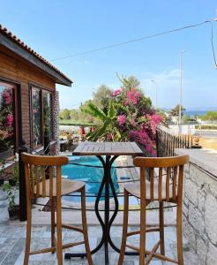 einen Tisch und zwei Stühle auf einer Terrasse mit Pool in der Unterkunft Ata Boutique Hotel in Altınyunus