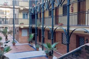 an apartment building with palm trees in the courtyard at En Patio sevillano Alameda-Isla Magica in Seville