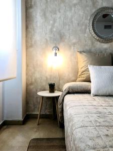 a bedroom with a bed and a table with a lamp at En Patio sevillano Alameda-Isla Magica in Seville