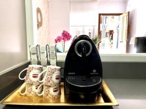 a coffee maker on a tray next to two mugs at En Patio sevillano Alameda-Isla Magica in Seville