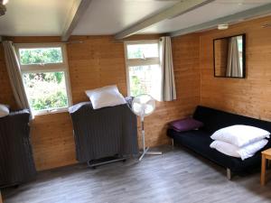 Lacapelle-MarivalにあるBungalow "les randonneurs"のソファと2つの窓が備わる客室です。