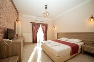 a hotel room with a bed and a television at Kuzey Park Hotel in Gokceada Town +47 photos