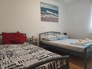 a bedroom with two beds and a painting on the wall at Apartman Luka in Vodice