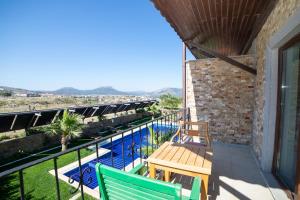 a balcony with two chairs and a swimming pool at Kuzey Park Hotel in Gokceada Town