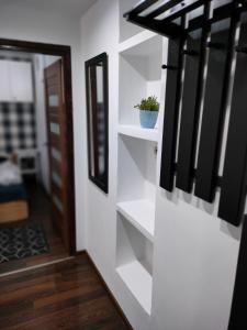 a stairway with white shelves and a mirror at Apartament Baldachówka in Rzeszów