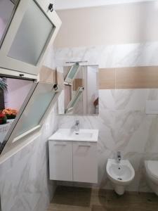 ein weißes Badezimmer mit Waschbecken und Toilette in der Unterkunft La Cocorita in Trapani
